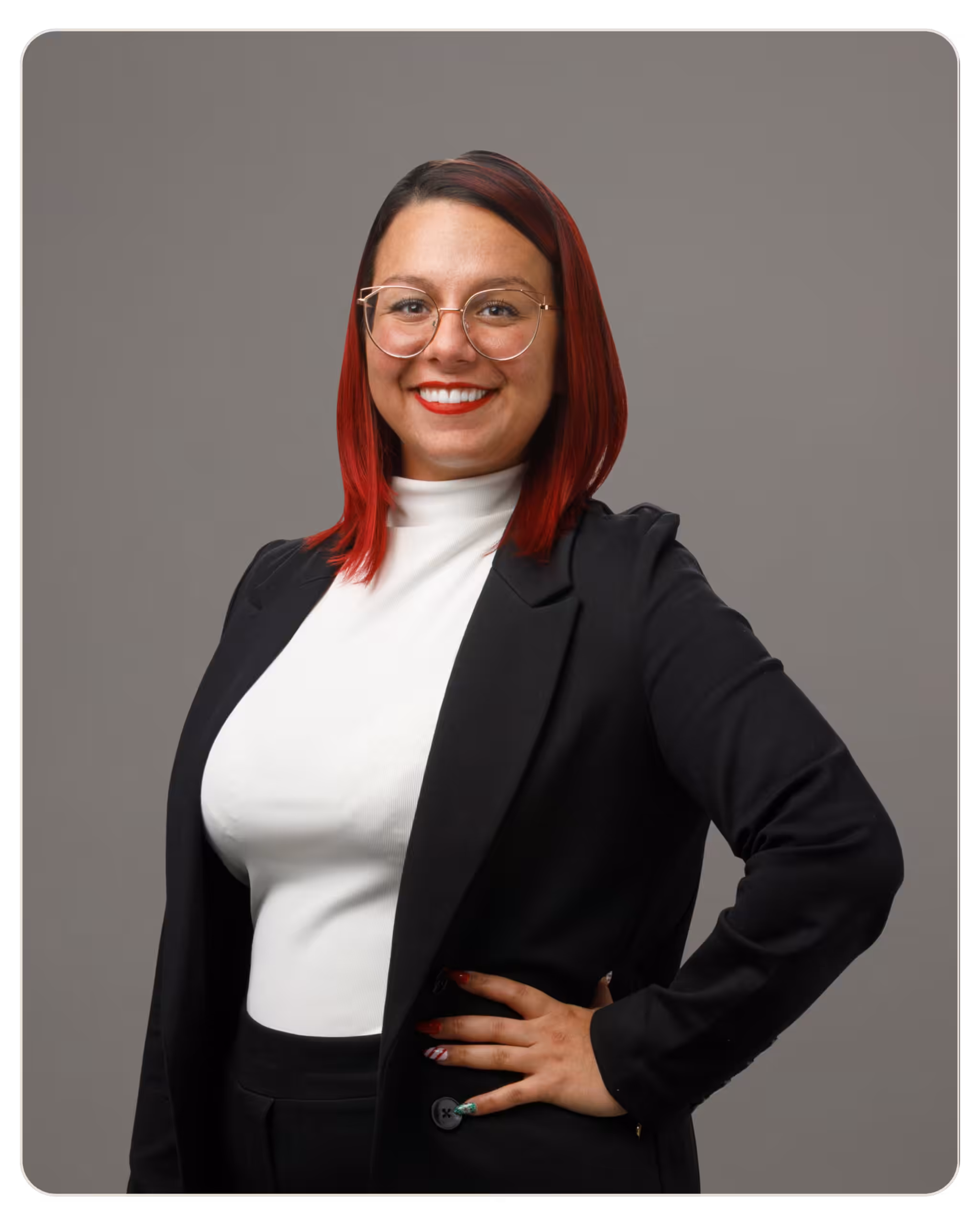 Kristina Mazzone, CAC: Patient Care Specialist at Kandela. Professional portrait of a smiling woman with red hair, round glasses, and a black blazer against a gray studio backdrop.