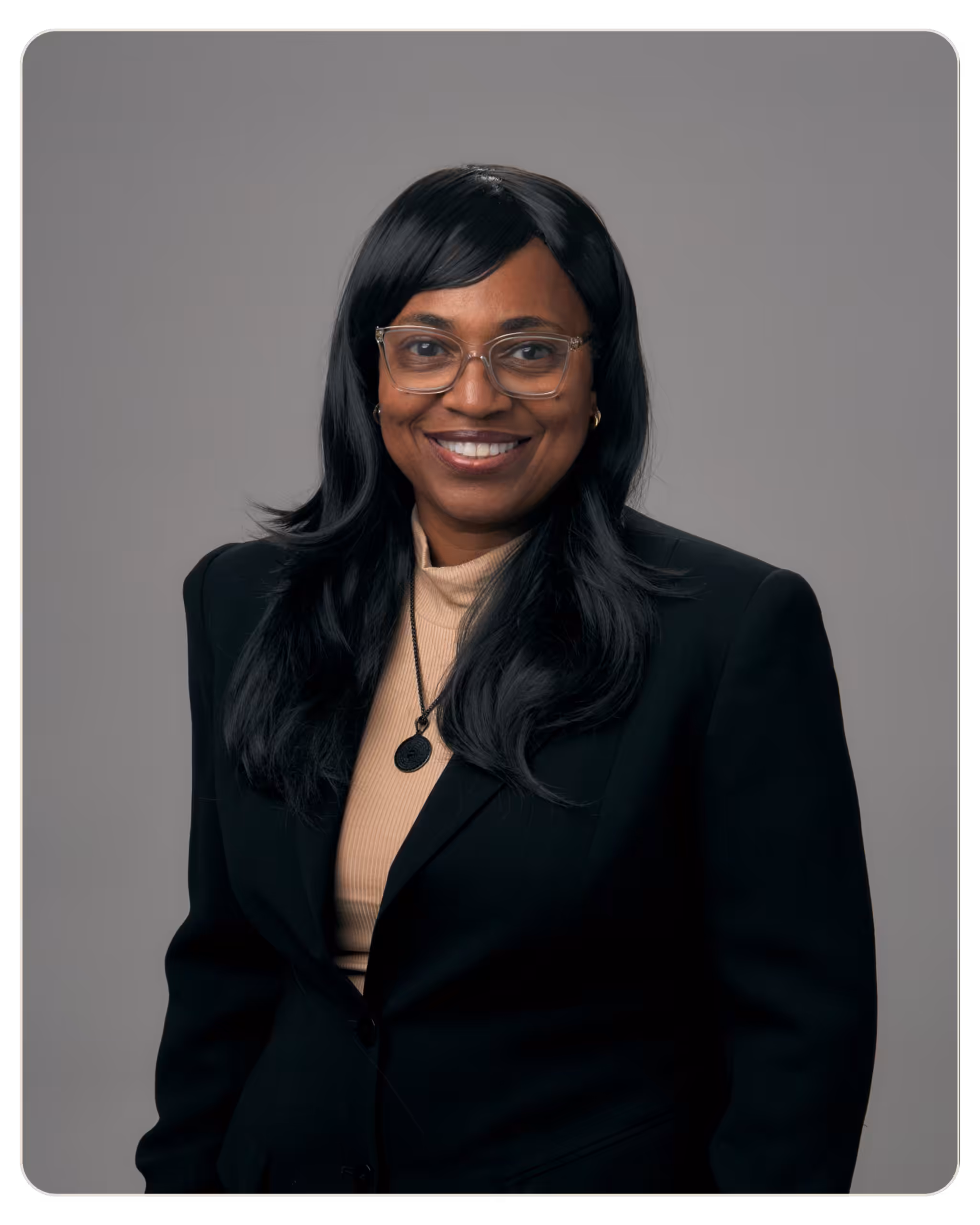 Robin Jeffrey: Recovery Coach at Beacon. Professional headshot of a smiling woman with glasses, wearing a black blazer and beige top against a gray backdrop.