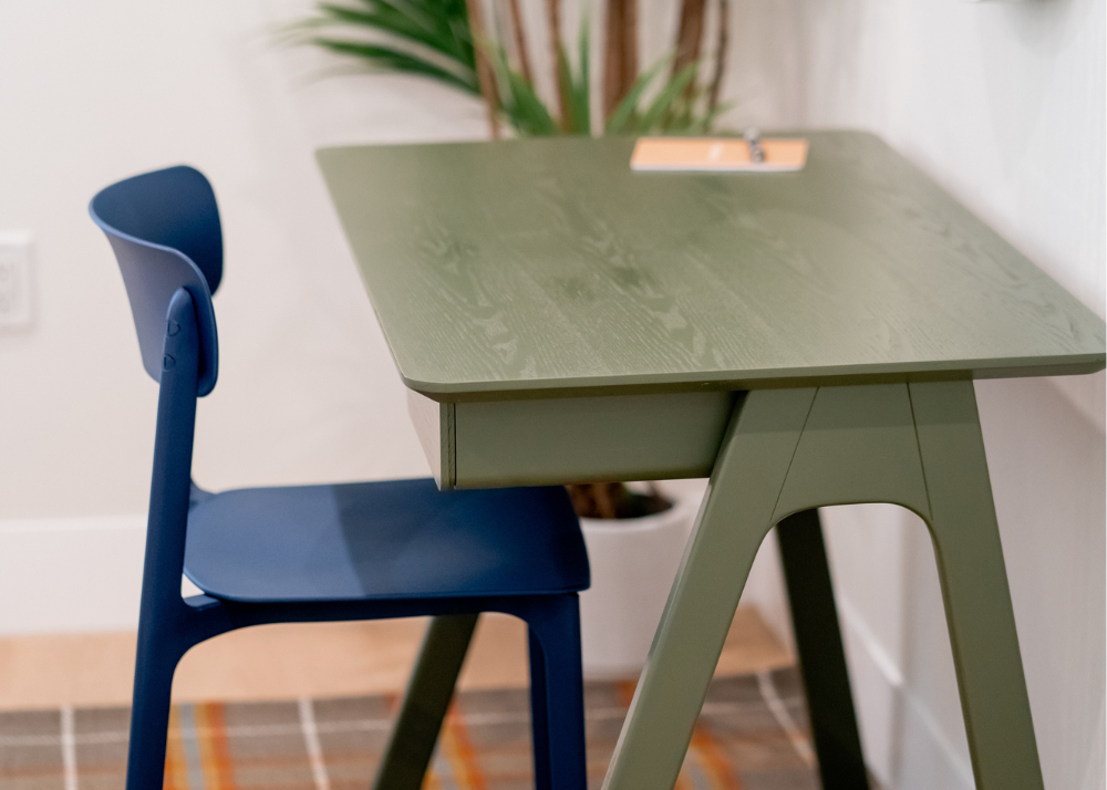 A green desk and blue chair